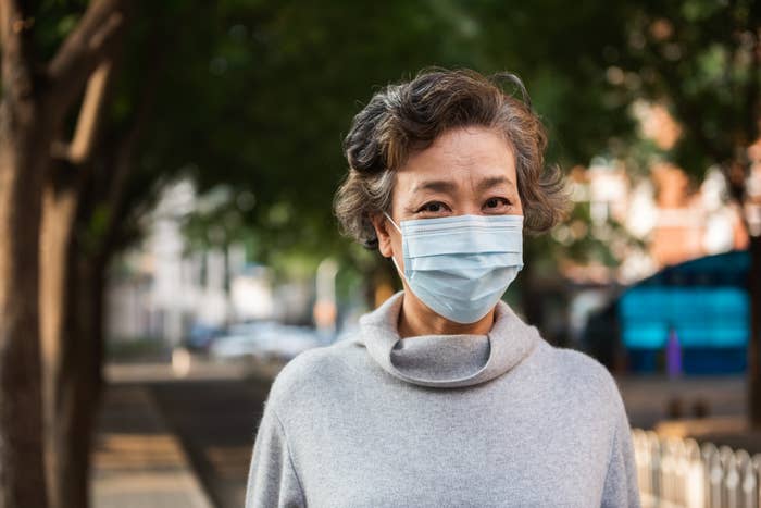 Older woman wearing surgical mask.