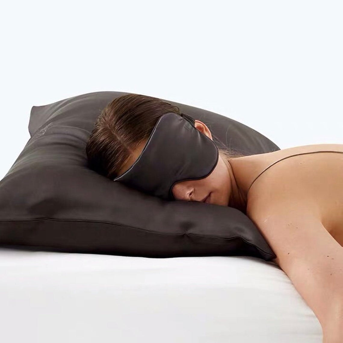 Model asleep on silk pillow with mask