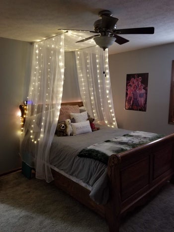reviewer pic of the lights hung over the bed with a sheer canopy