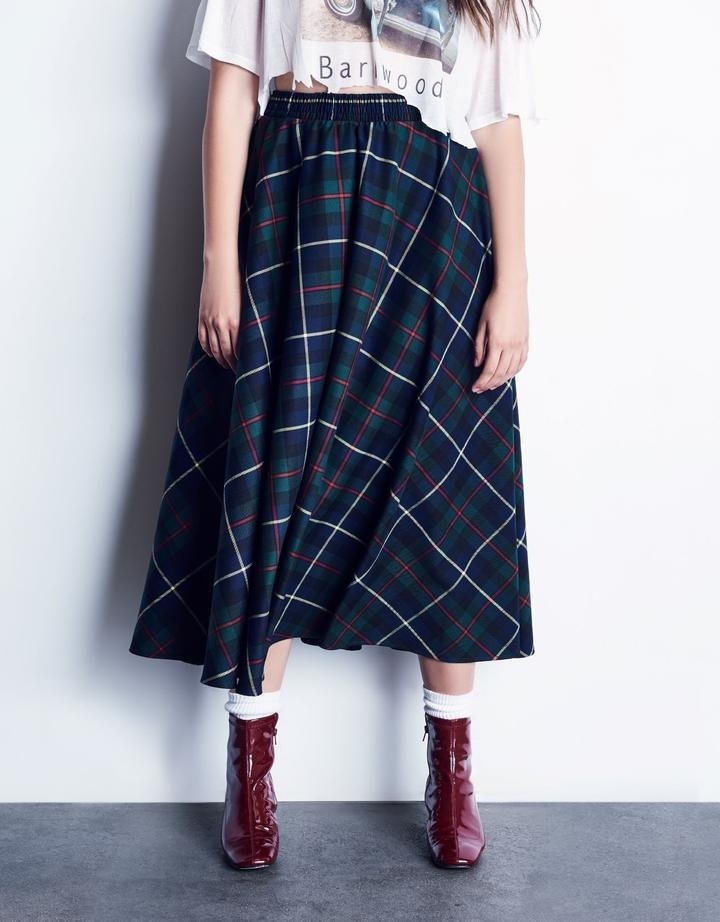 Model wearing the green plaid A-line skirt with an elastic waist