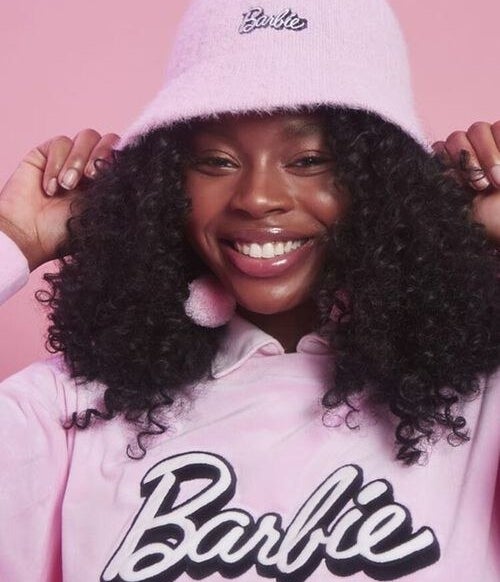 Model wears the pink bucket hat with black and pink barbie embroidery