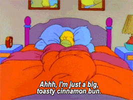 Homer from The Simpsons being cozy in bed