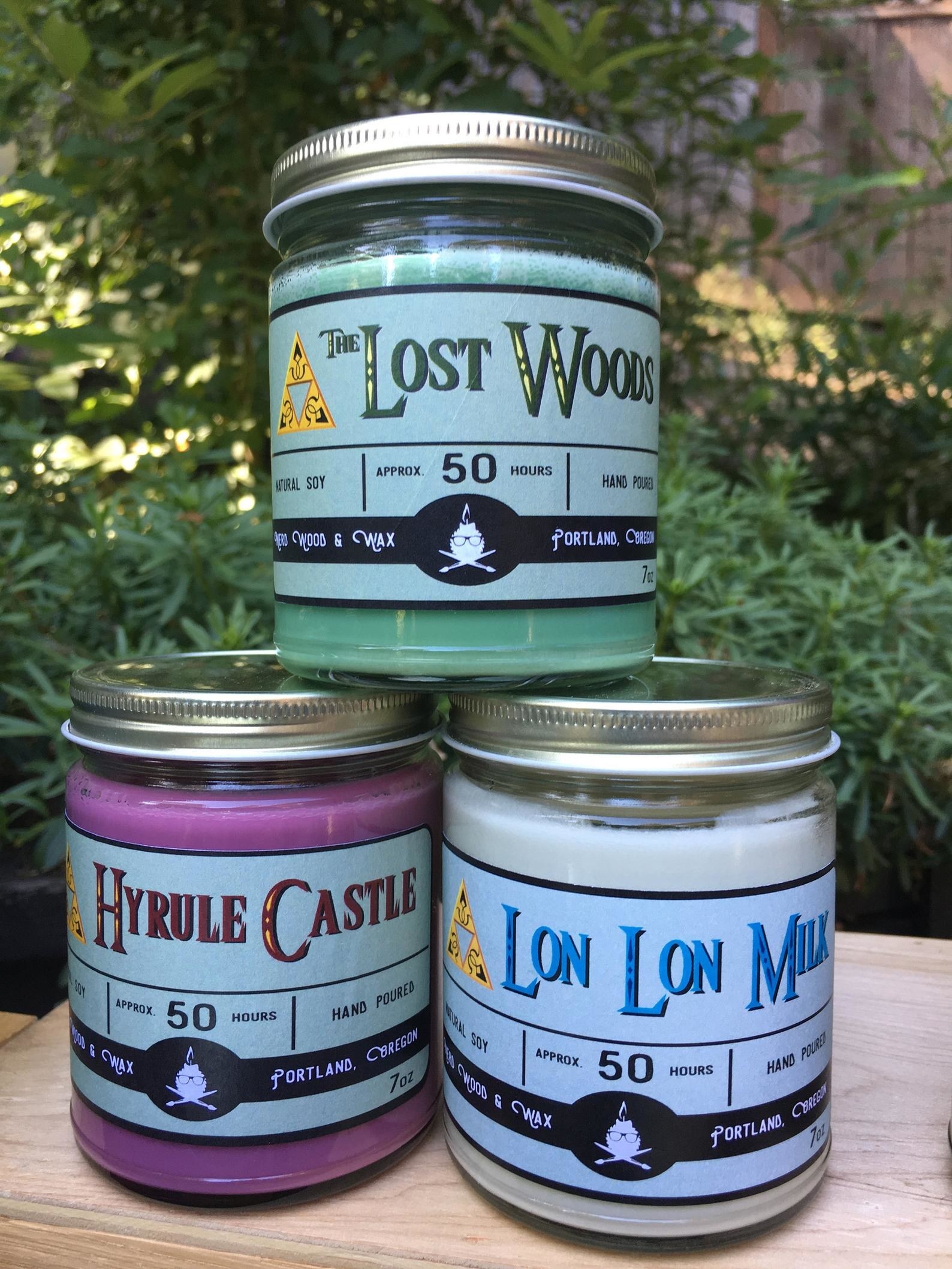 a green lost woods candle, a purple hyrule castle candle, and a white lon lon milk candle