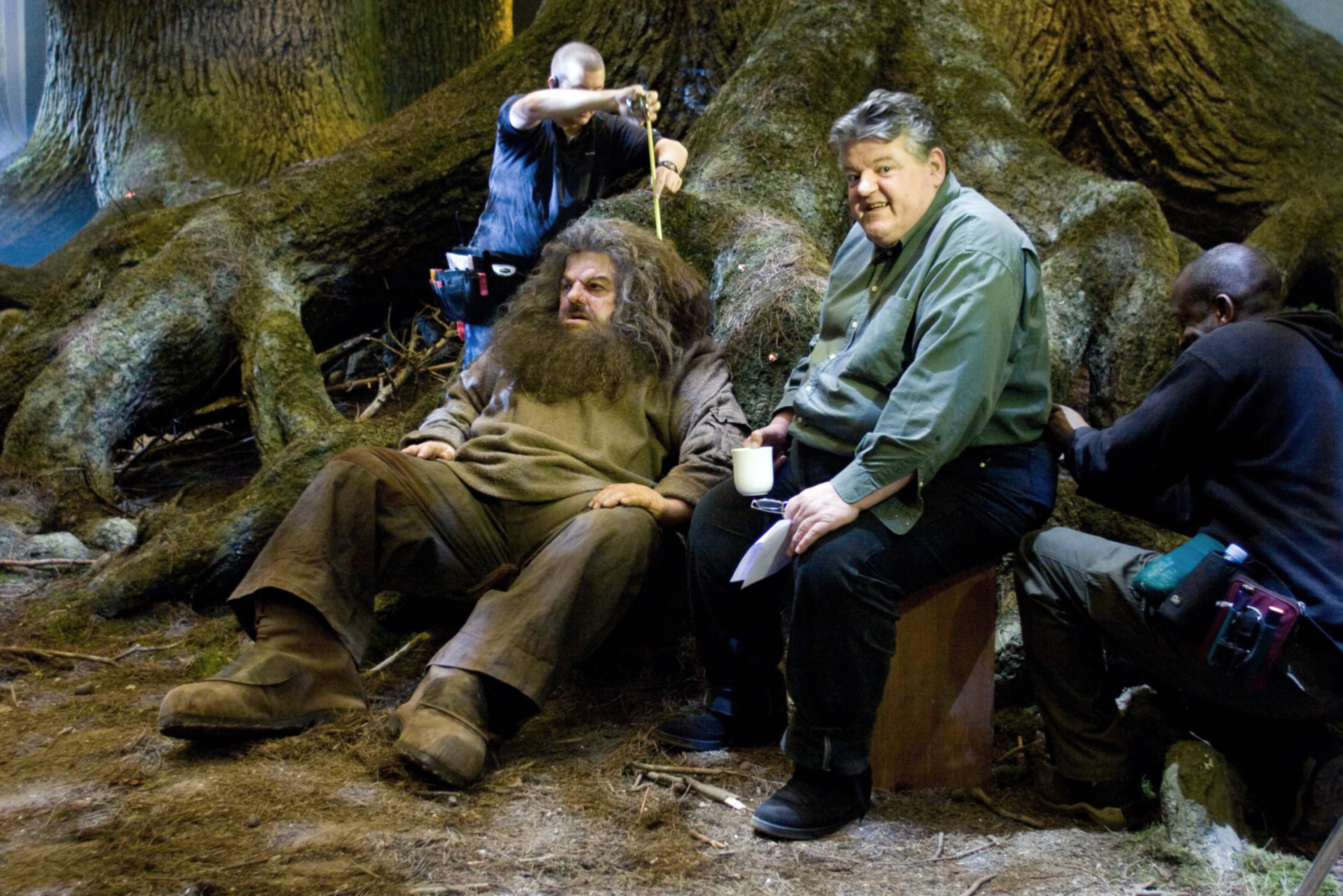 the actor for Hagrid, Robbie Coltrane, posing next to a fake human-sized doll Hagrid