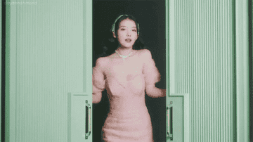 IU smiles and winks before she closes two large doors