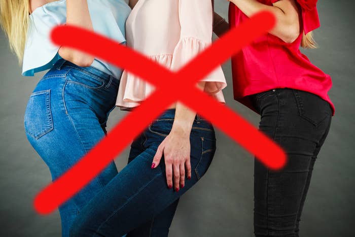 A closeup of women wearing skinny jeans with a giant X over it
