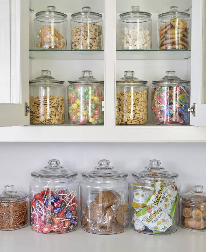 glass jars full of candies and snacks sitting on shelves 