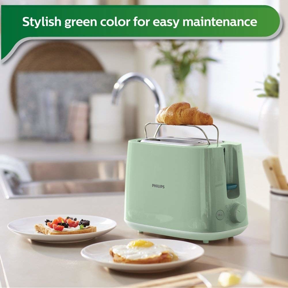A green toaster next to breakfast food items 