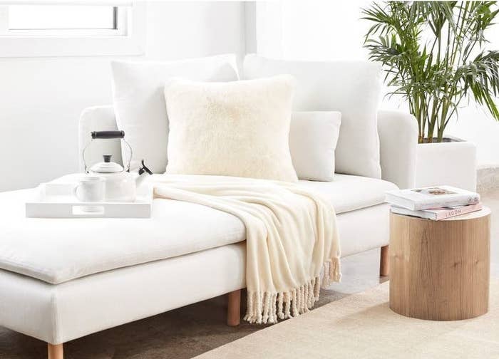 The blanket, in ivory, on a white chaise lounge