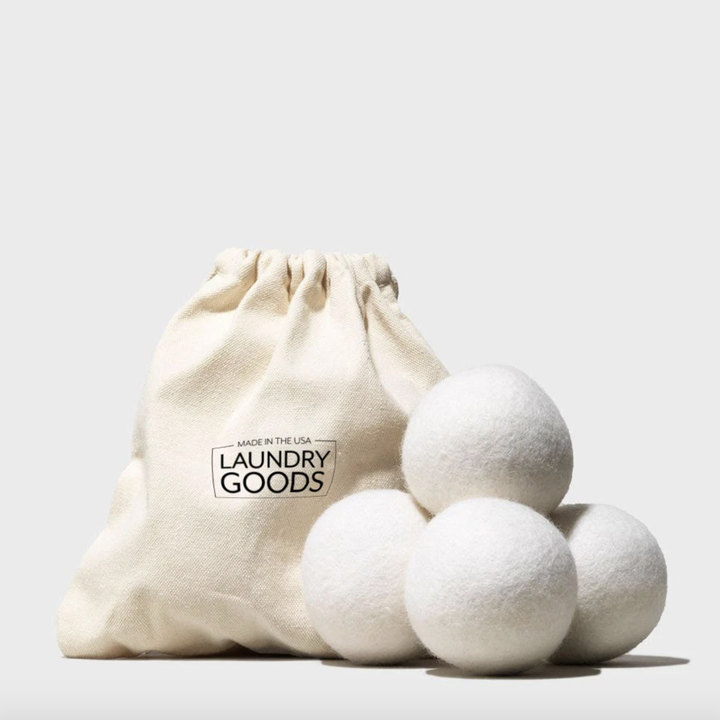 Four wool dryer balls next to drawstring bag
