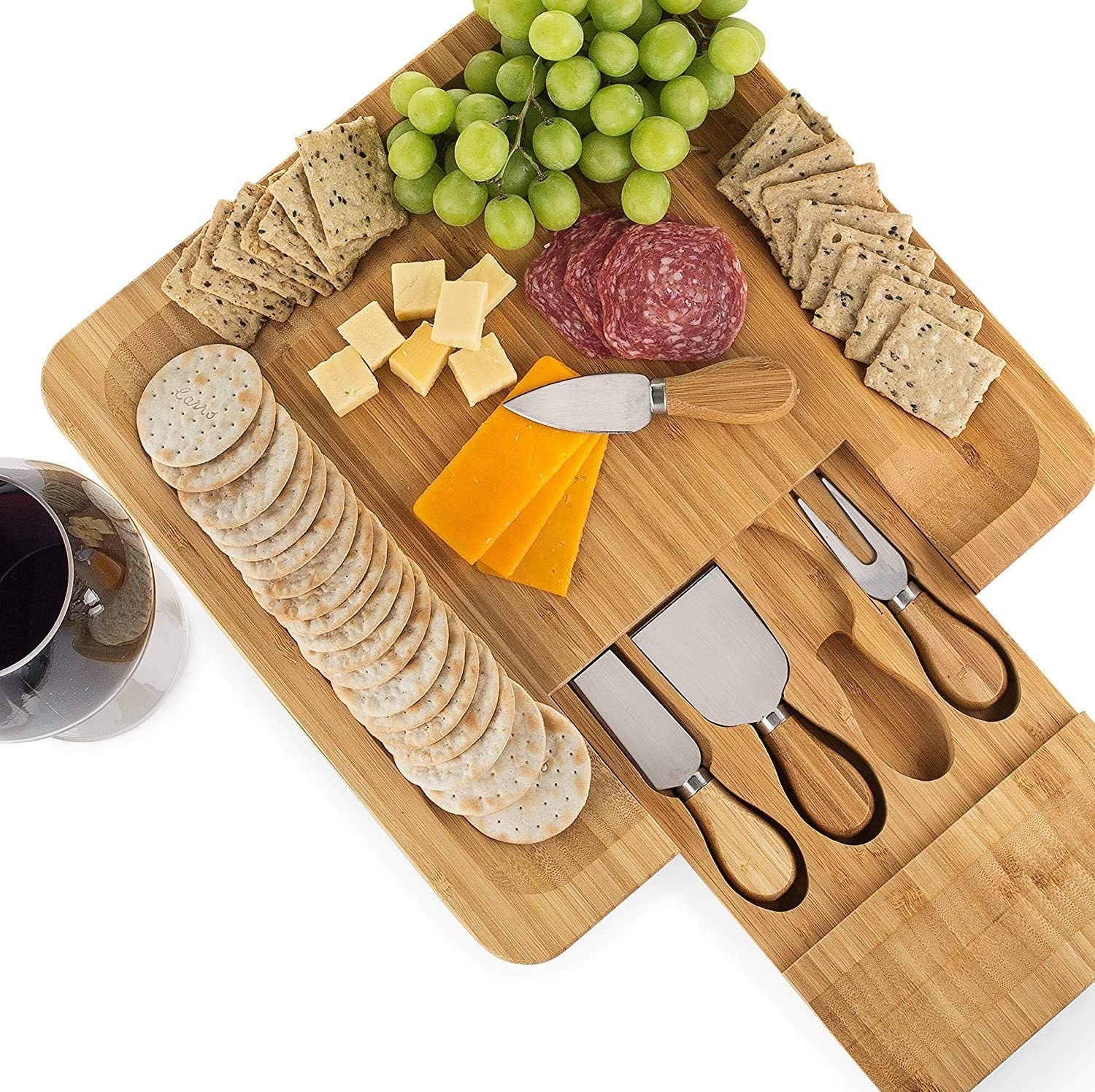 the charcuterie board with cheeses, crackers, and grapes