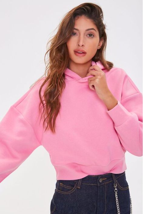 model wearing pink hoodie with dark jeans