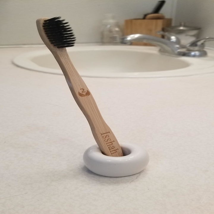 Reviewer photo of bamboo toothbrush placed in holder