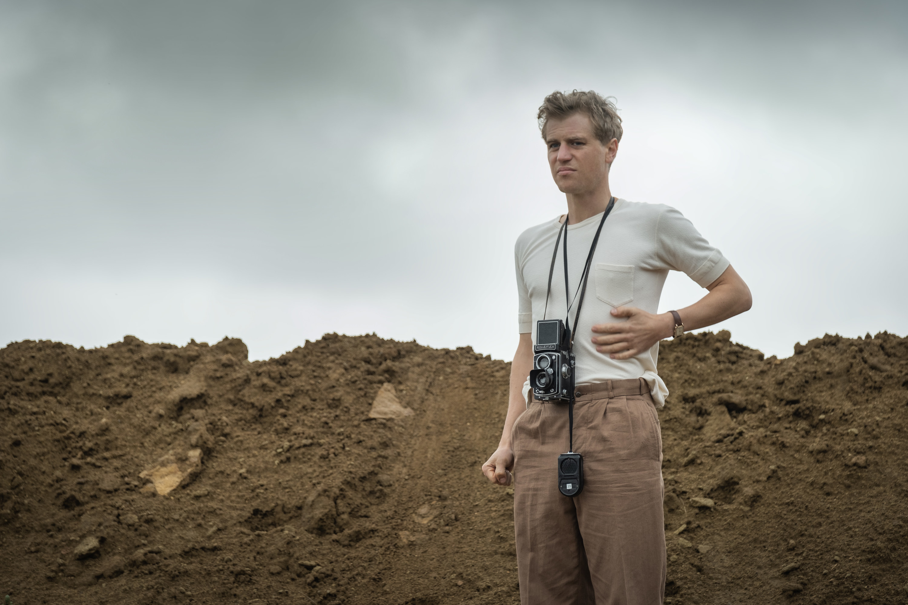 Still from The Dig: Rory Lomax on-site with a camera around his neck