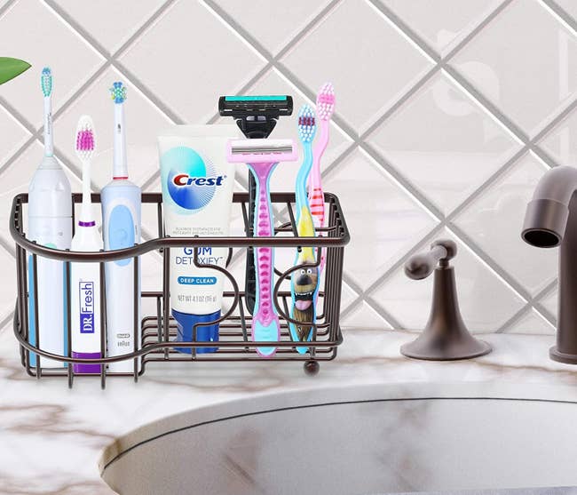 Wire toothbrush holder with toothbrushes, toothpaste, and razors placed inside