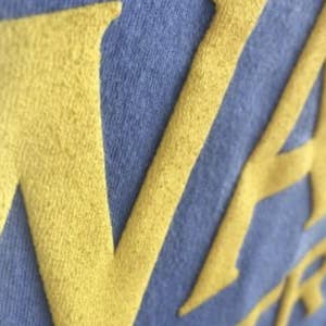 closeup of the T-shirt to show raised fabric text