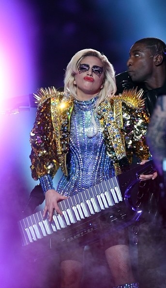 Lady Gaga playing a keyboard and wearing a sparkling outfit