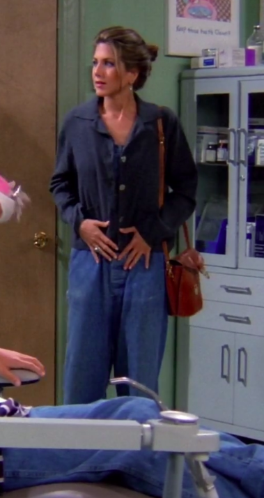 Rachel wearing a shoulder bag, a cardigan, and overalls