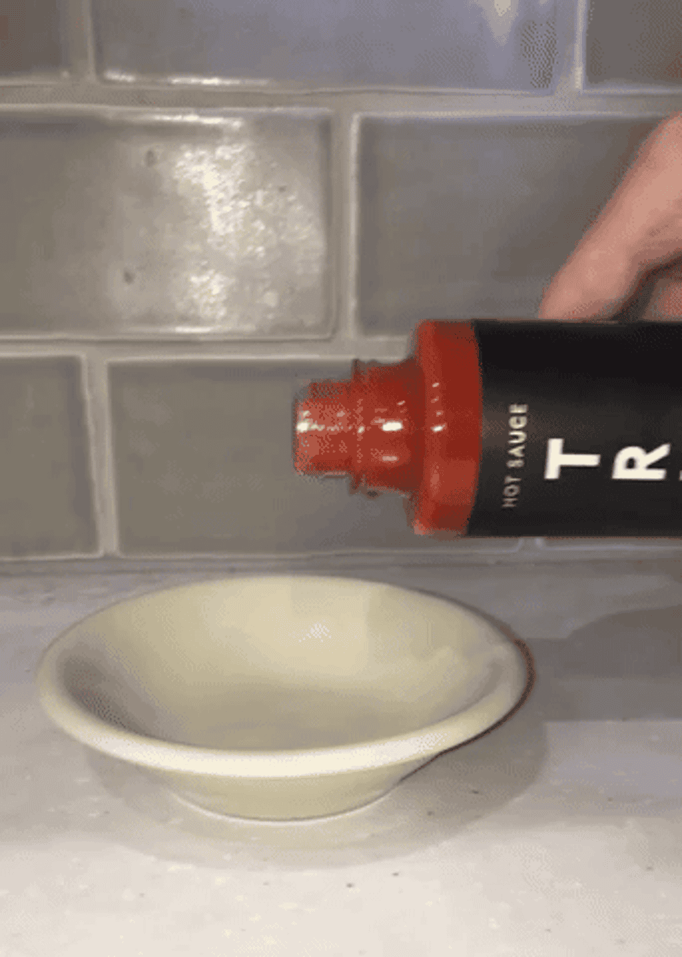 Gif of the writer pouring some of the Original Truff sauce into a dish to show its consistency and color