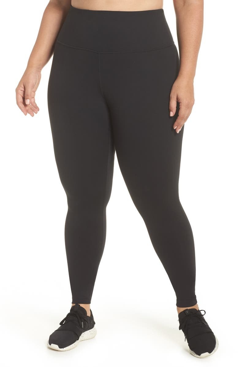 A model wearing the leggings, in black, with matching black and white shoes
