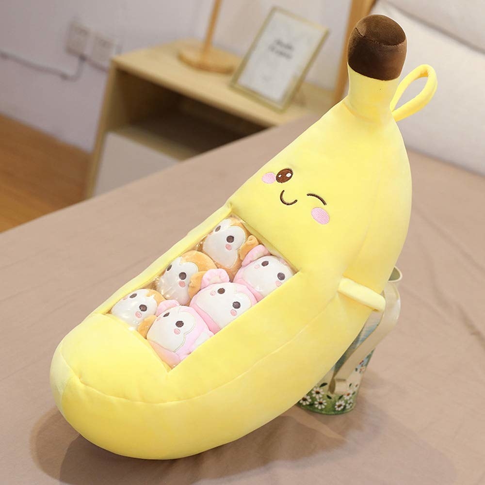 a banana plushie filled with smaller monkey plushies inside