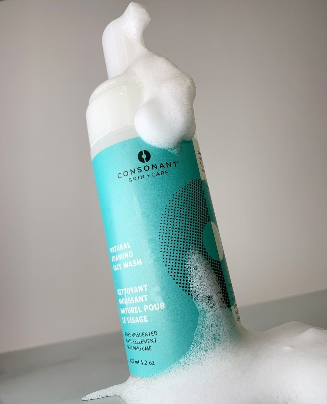 A bottle of the face wash covered in foam