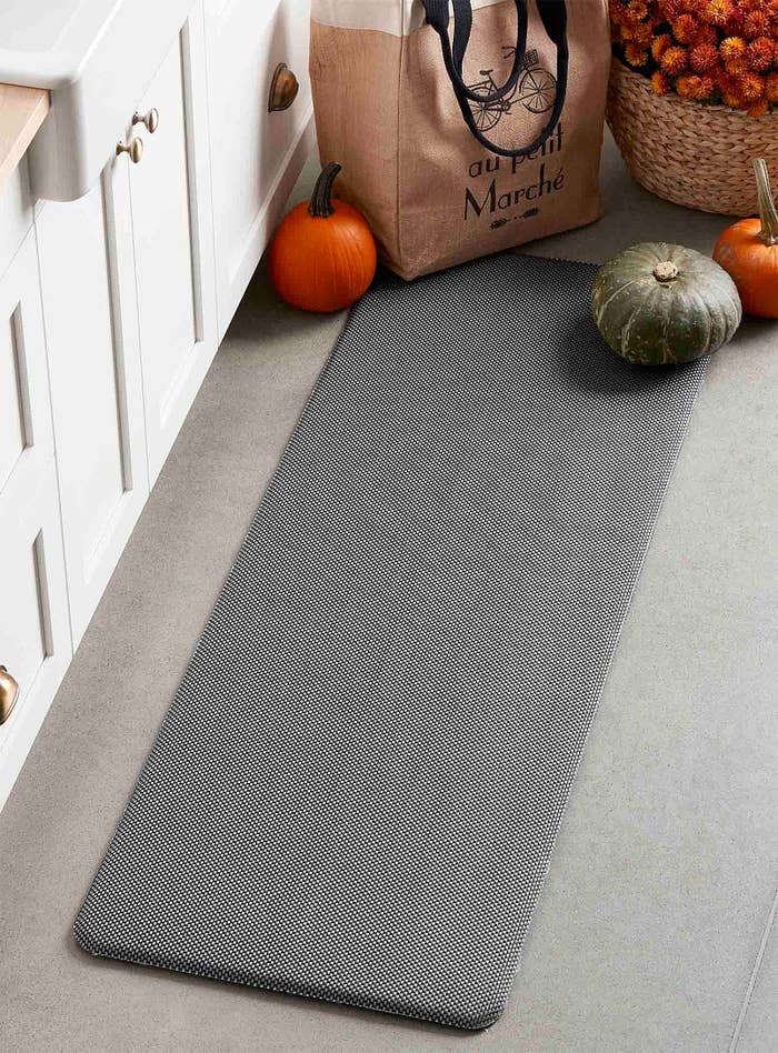A thick long mat in front of a kitchen counter