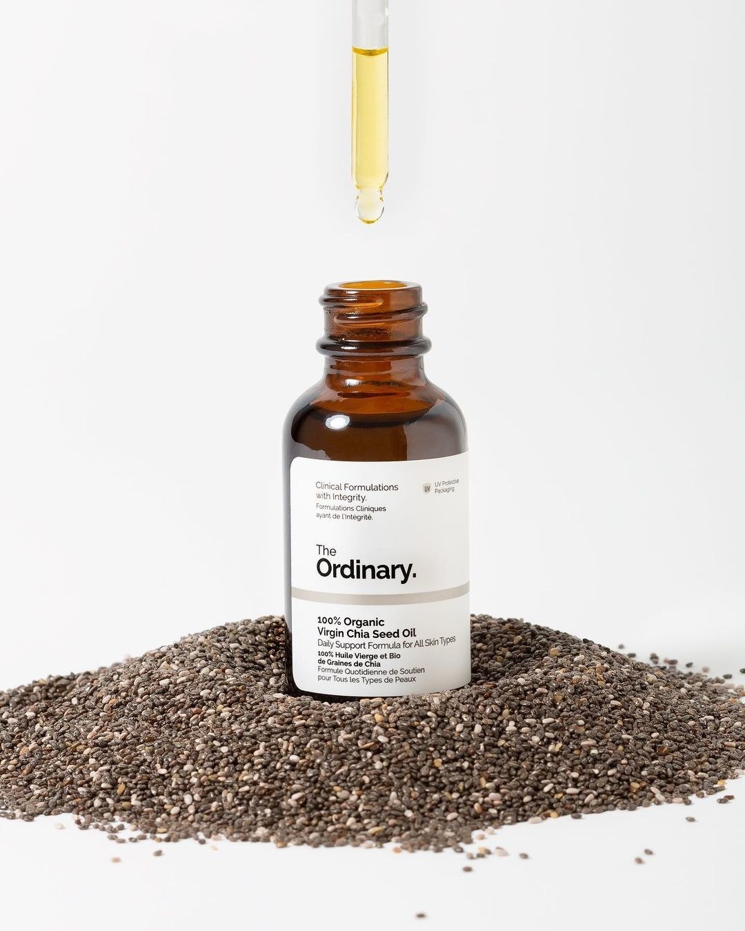 A bottle of the chia seed oil on a bed of chia seeds