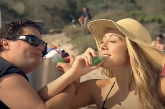 Bobby Moynihan and Colbie Caillat sipping drinks on the beach in the &quot;Fallin&#x27; for You&quot; music video