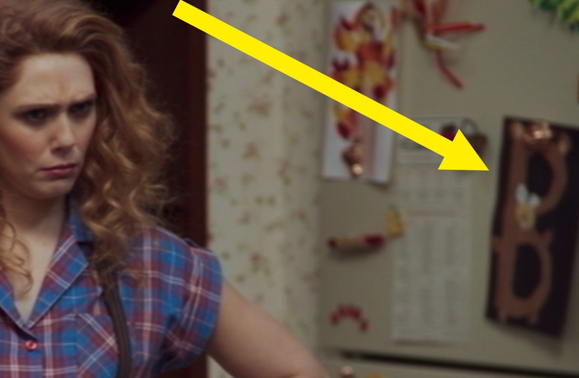 An arrow pointing out a brown "B" in the shape of a bear on Wanda's fridge