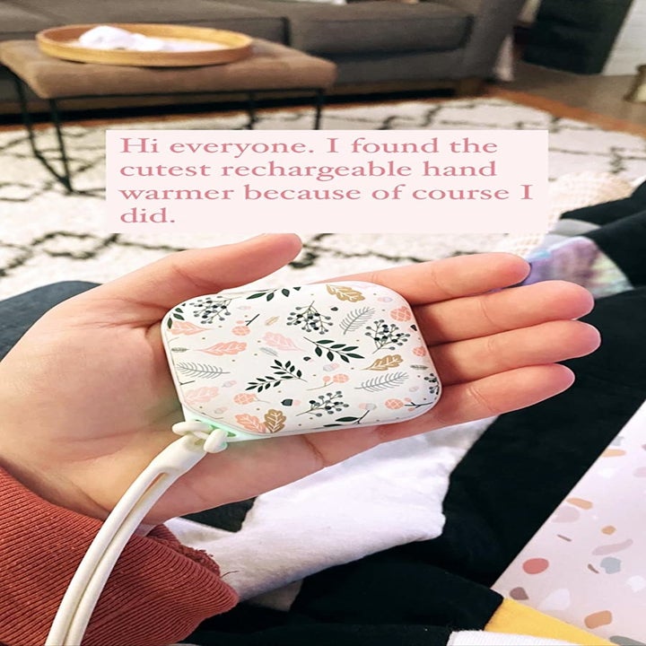 A reviewer holding the hand warmer in flower pattern