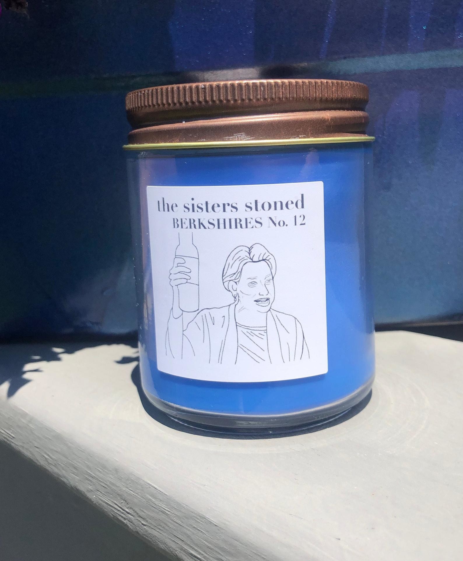 The blue candle with an illustration of Dorinda from RHONY holding a bottle of wine