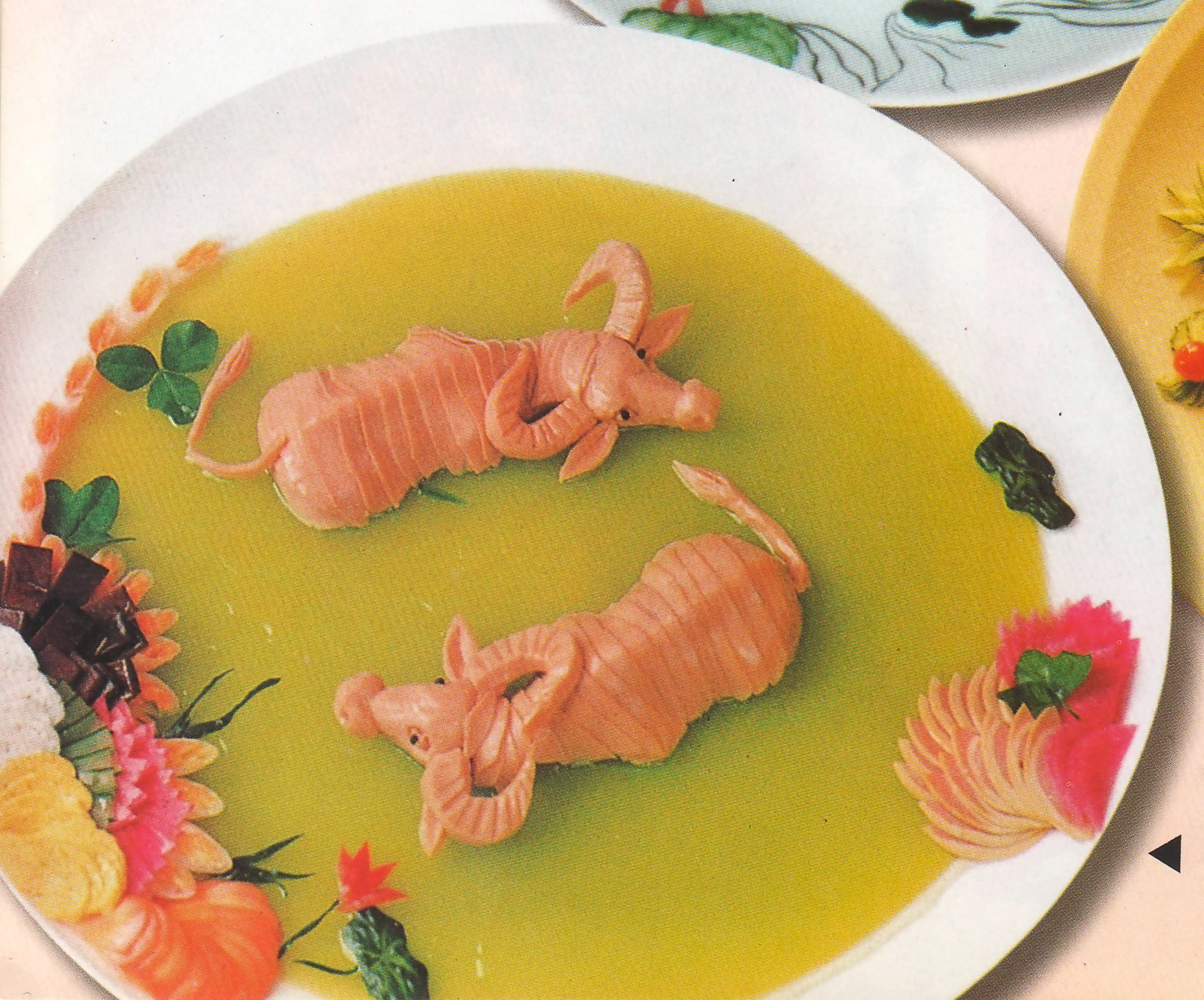 Two swimming water buffalo are made out of ham on a specially designed plate of food