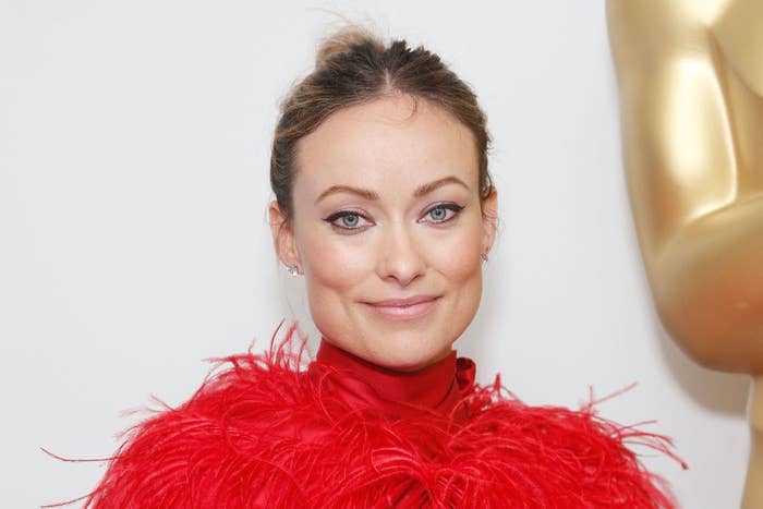 Olivia Wilde wearing a feathered outfit and her hair up in a bun