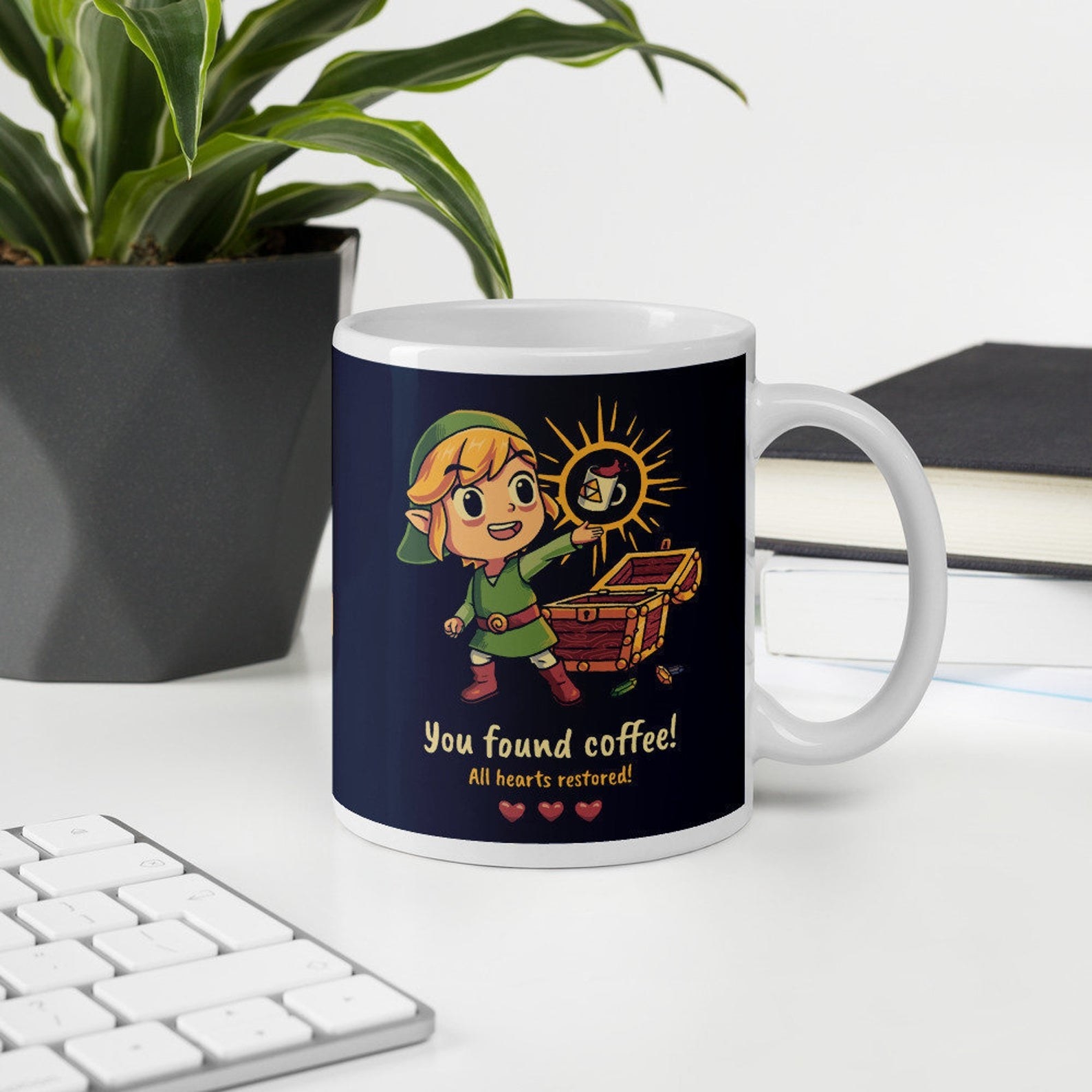 a mug with a cartoon-like link on it holding up a mug and the words &quot;you found coffee! all hearts restored!&quot;