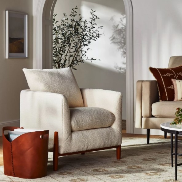 The cream sherpa chair with wood legs in a living room