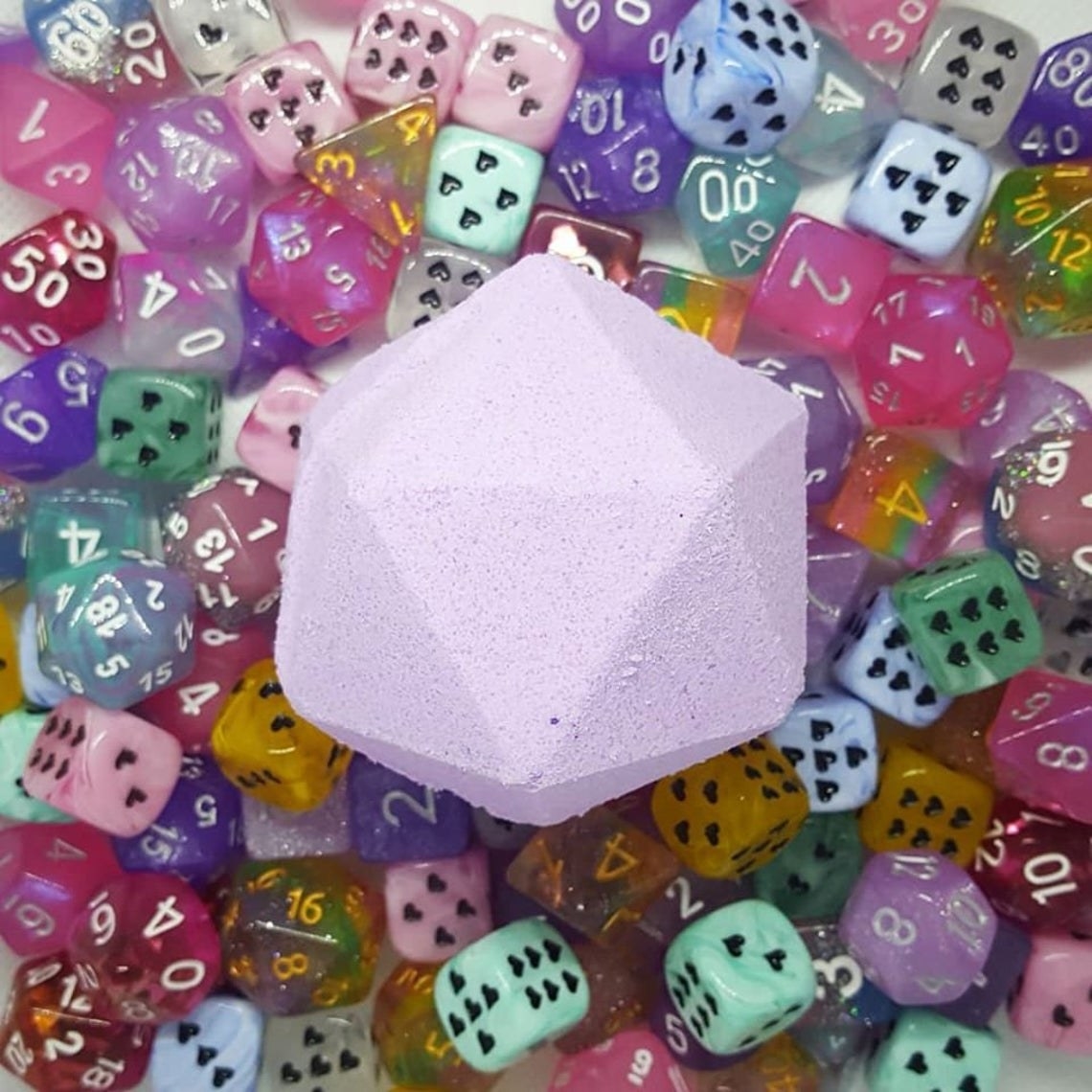 20-sided die bath bomb on pile of dice with various sides