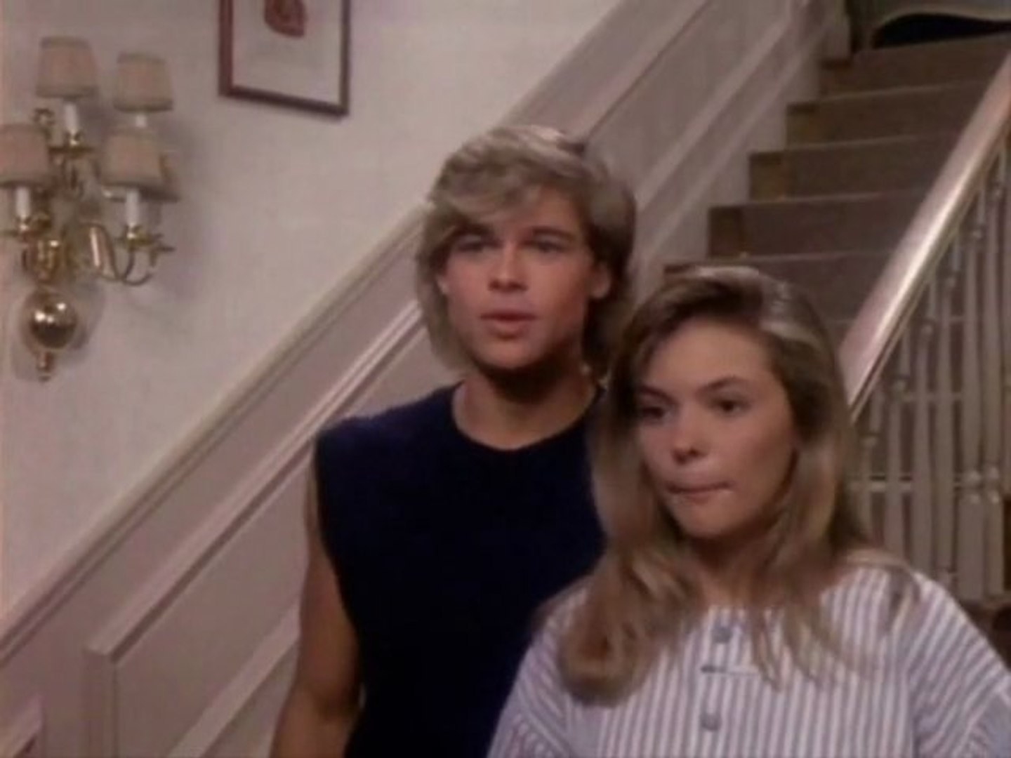 Screenshot from &quot;Dallas&quot; of Brad Pitt next to a blonde actress in front of a staircase 