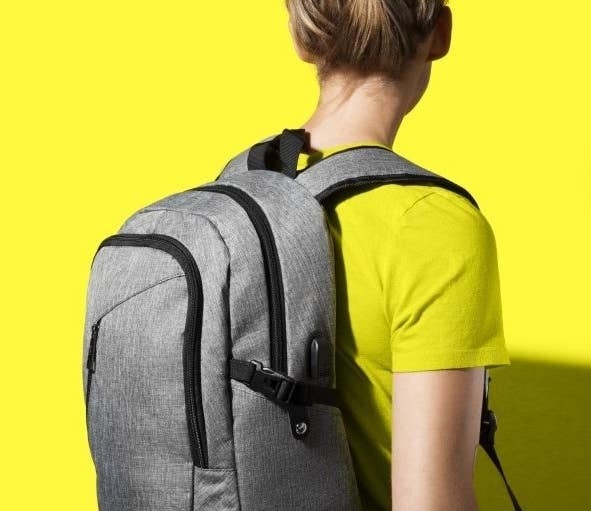 A person wearing the backpack in grey