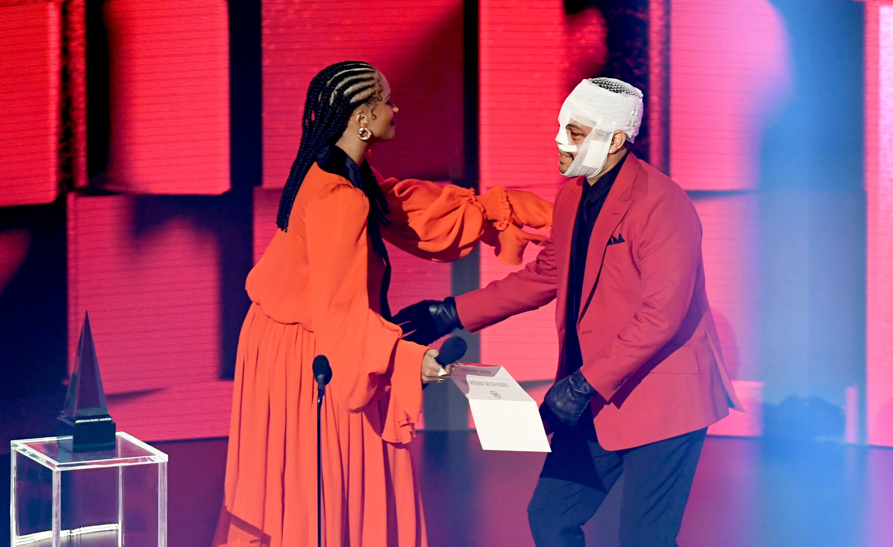 The Weeknd accepts an award from Ciara at the 2020 American Music Awards