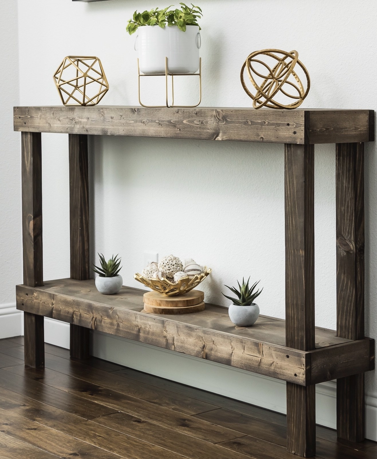 The table, which has a raw wood look, and one lower open storage shelf