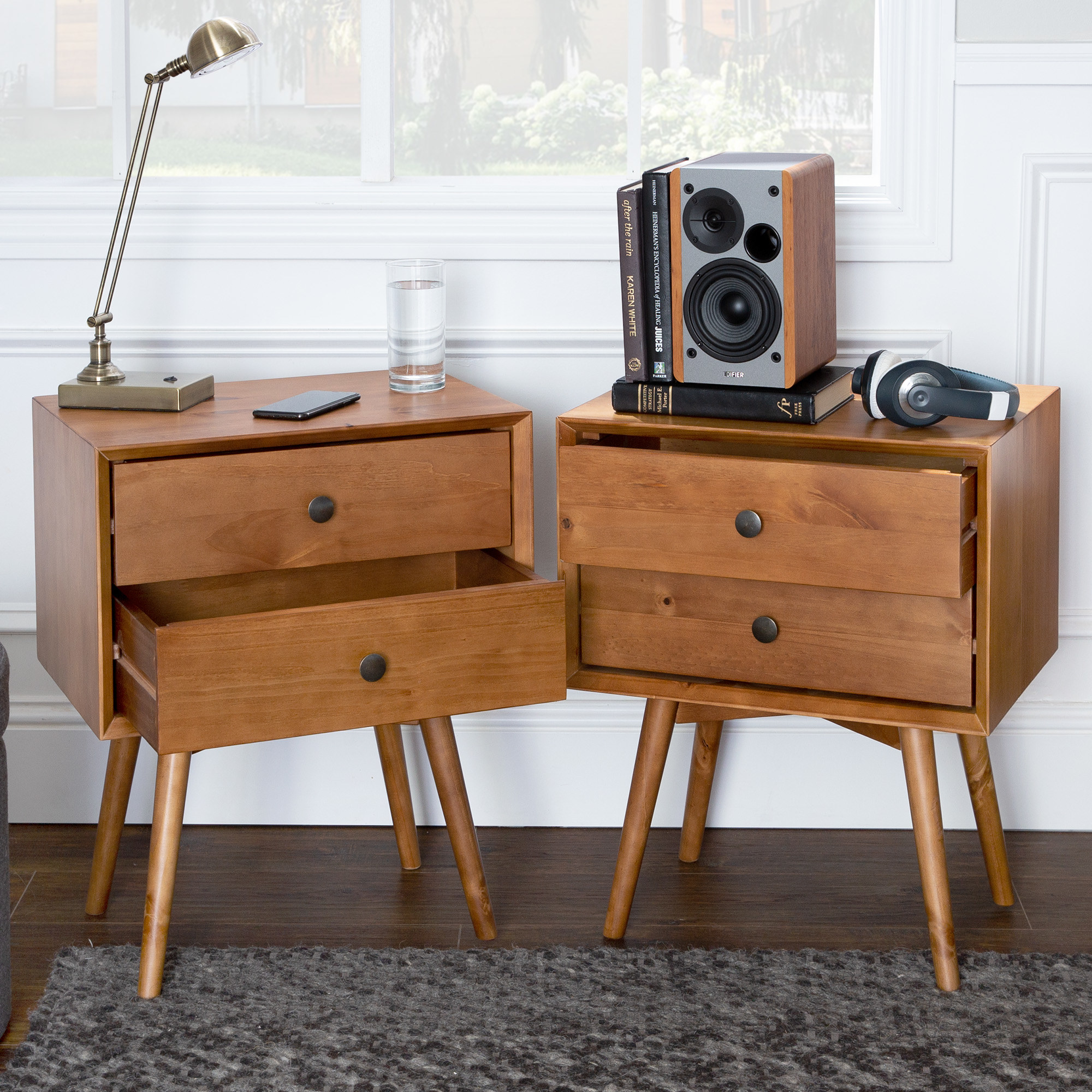 The two nightstands, which have four thin splayed legs, two drawers each, and a low, rectangular silhouette