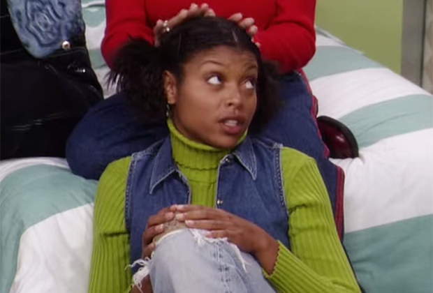 Taraji in a lime green turtle neck sitting on the floor in front of a bed with someone sitting behind her