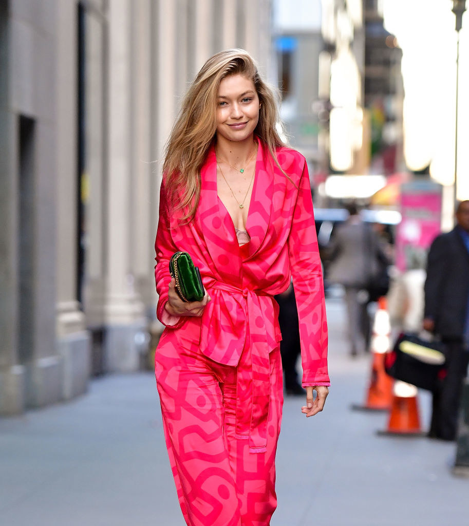 Gigi in walking outside in New York City in a matching patterned blouse and pants