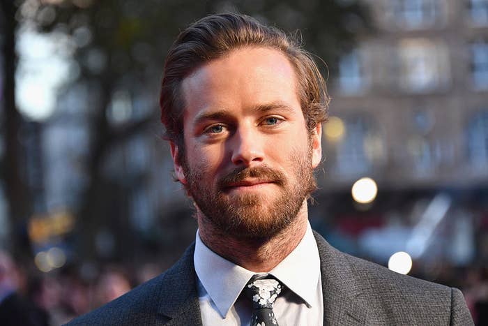 Armie with a full beard and black and white suit