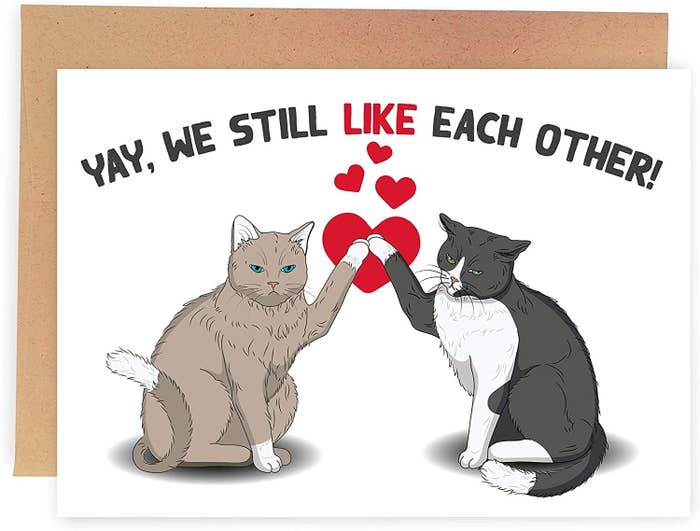 A drawing of two cats who are high-fiving, with the words &quot;Yay, we still like each other&quot; written over them in black ink