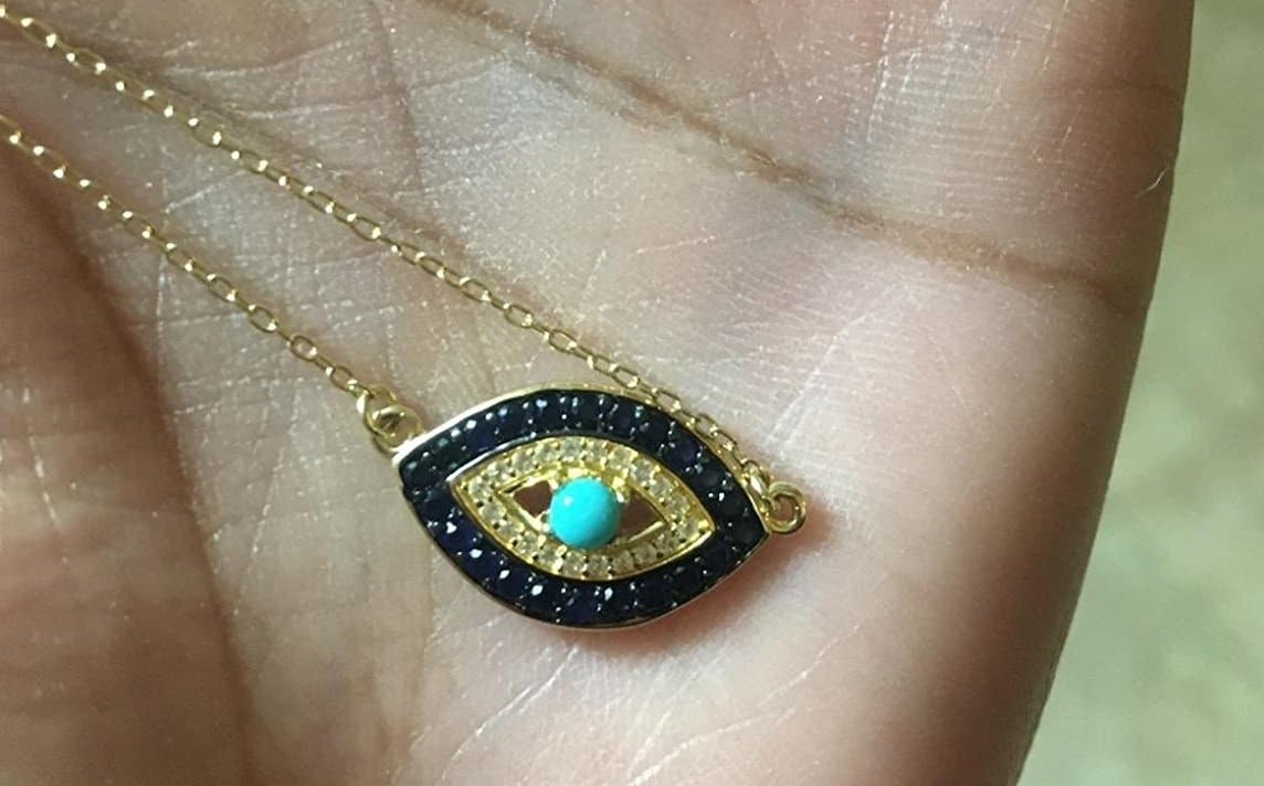 Reviewer holding the evil eye necklace