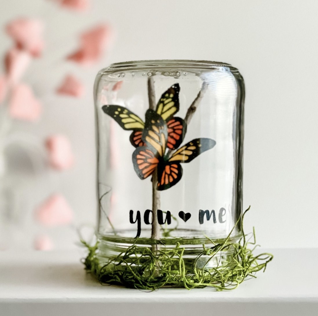 A jar upside down with two butterflies inside