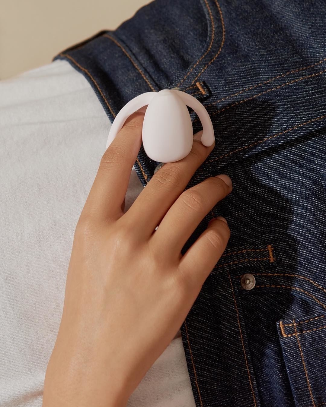A person holding the vibrator against their jeans