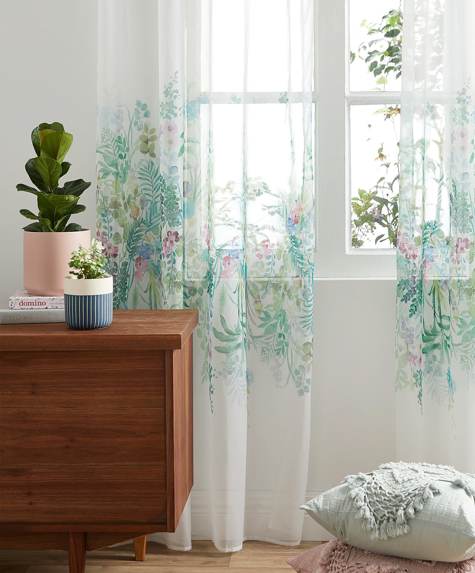 The sheer curtain hanging off of a rod above a window